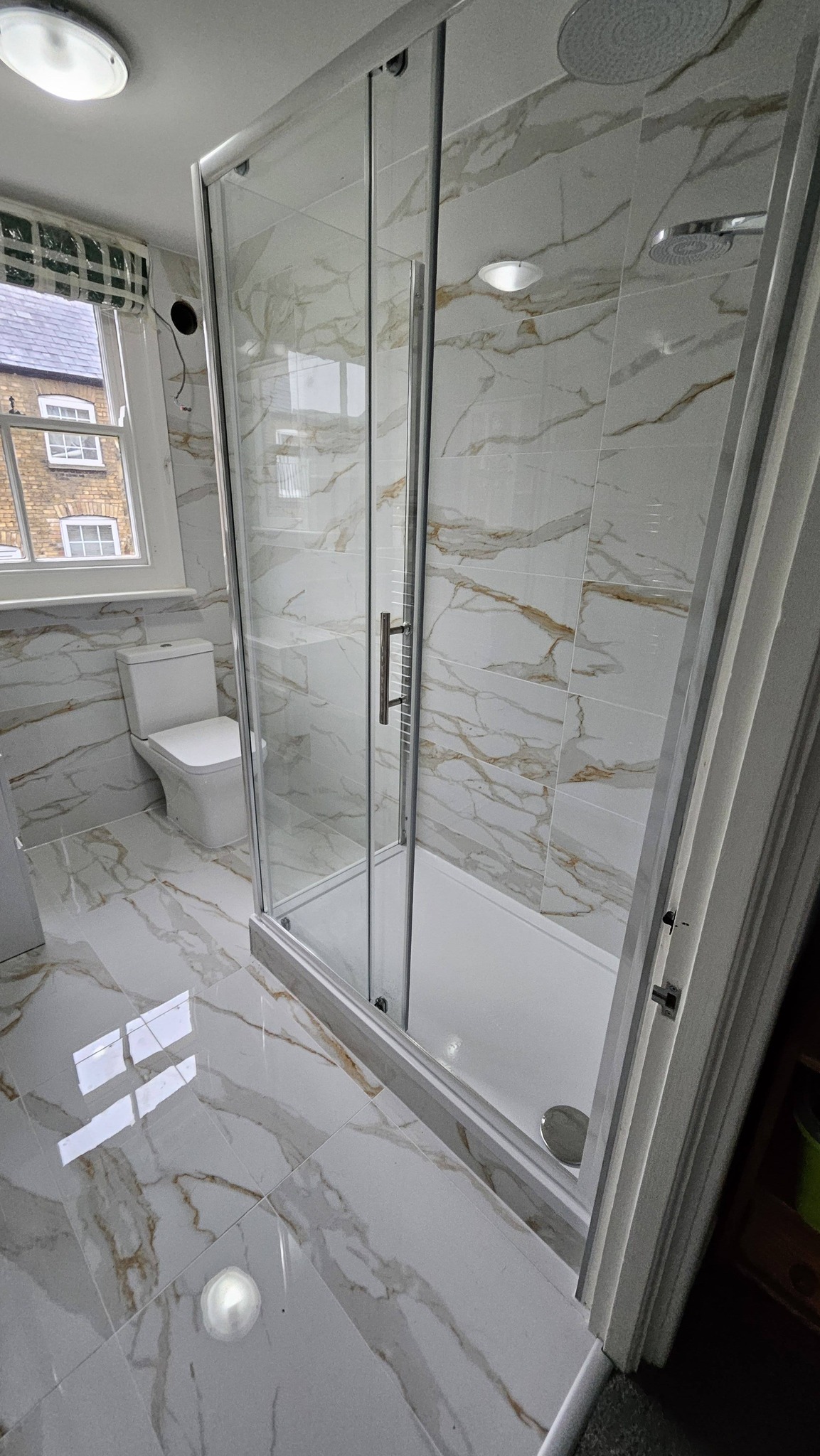 Gold and white marble bathroom with glass shower