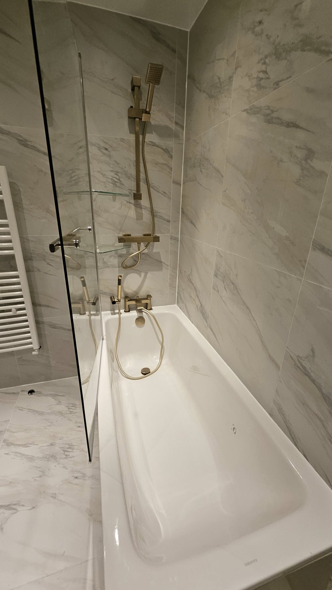 Marble tiled bathtub with gold fixtures
