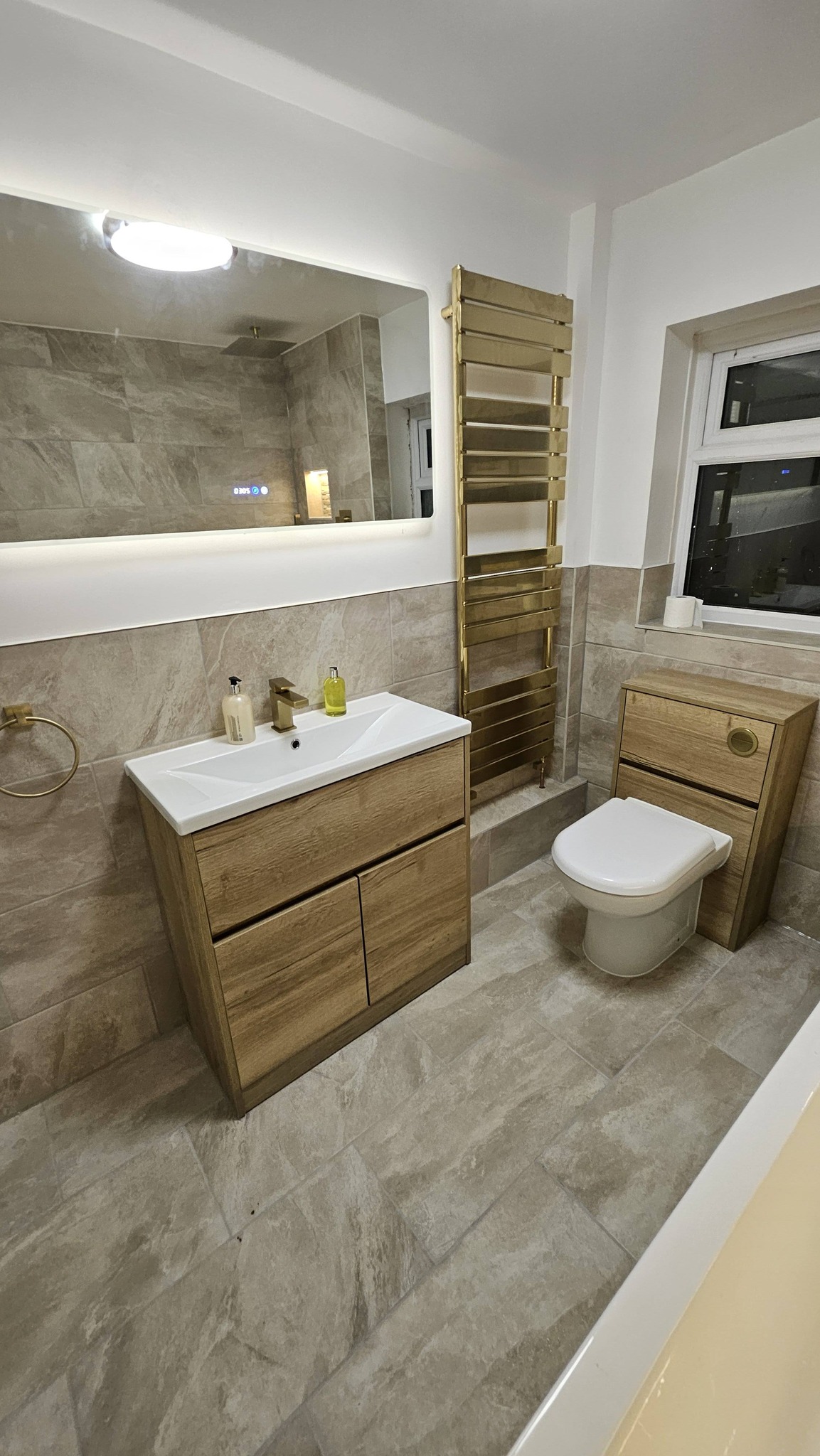 Oak vanity unit with gold towel rail and LED mirror