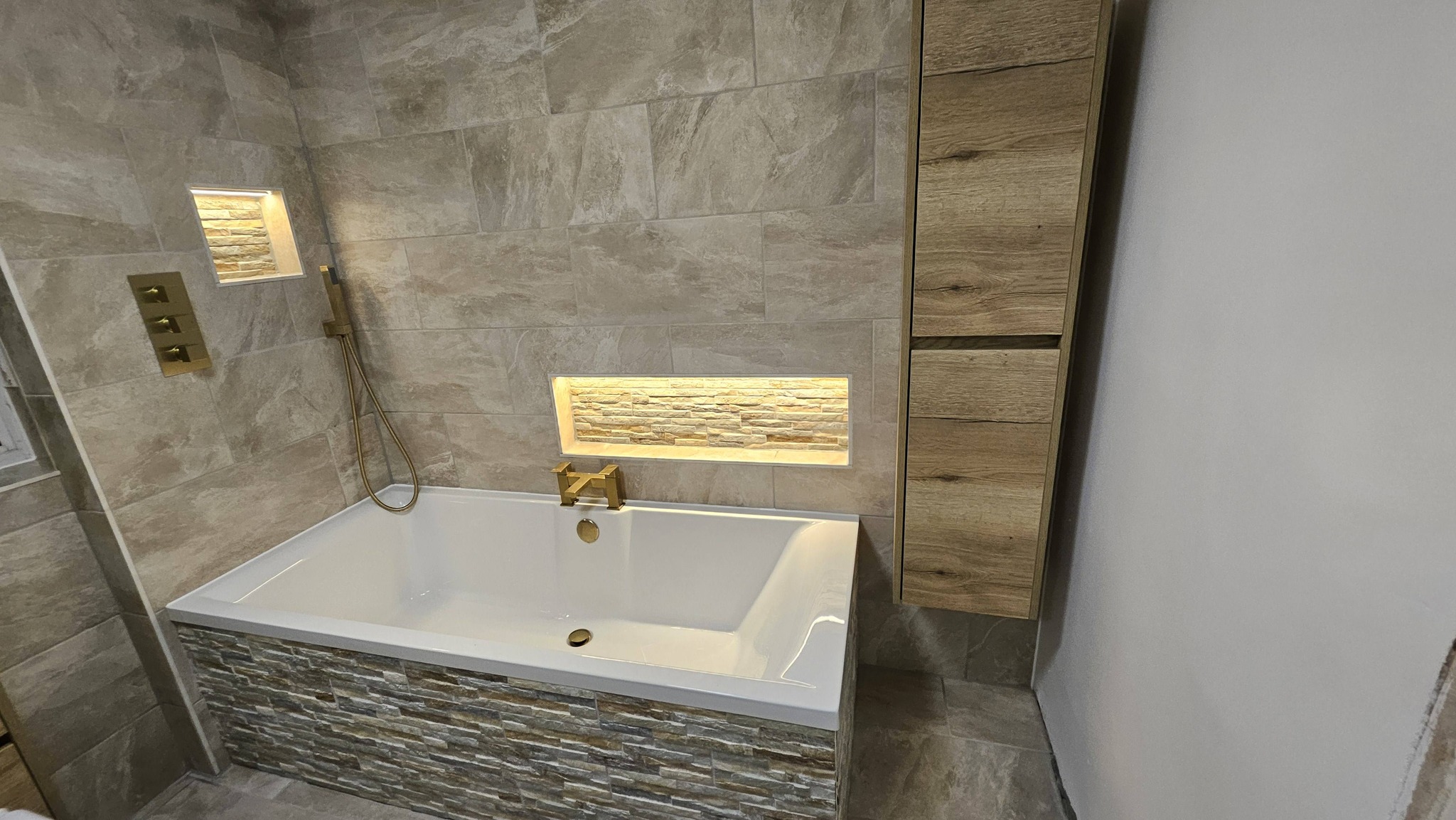 After: Stone-tiled luxury bath with LED niches