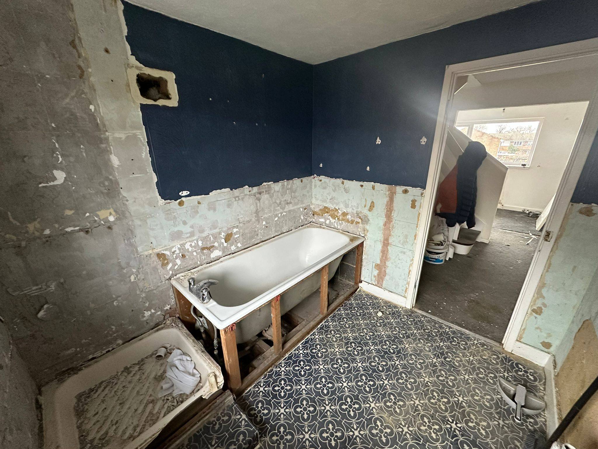 Before: Gutted bathroom with blue walls